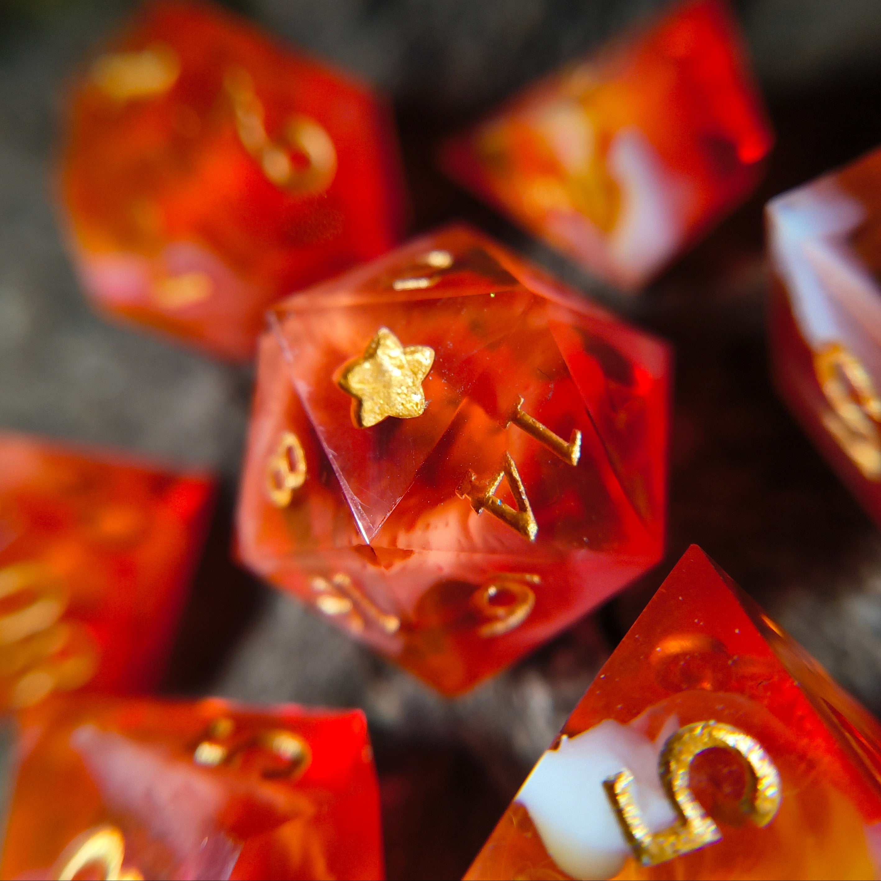 Close-up of orange polyhedral dice with white swirls on a wood surface