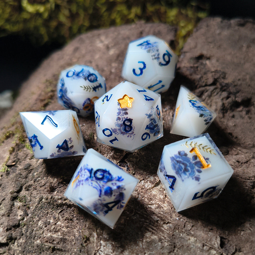 Set of white dice with porcelain patterning on a wood surface
