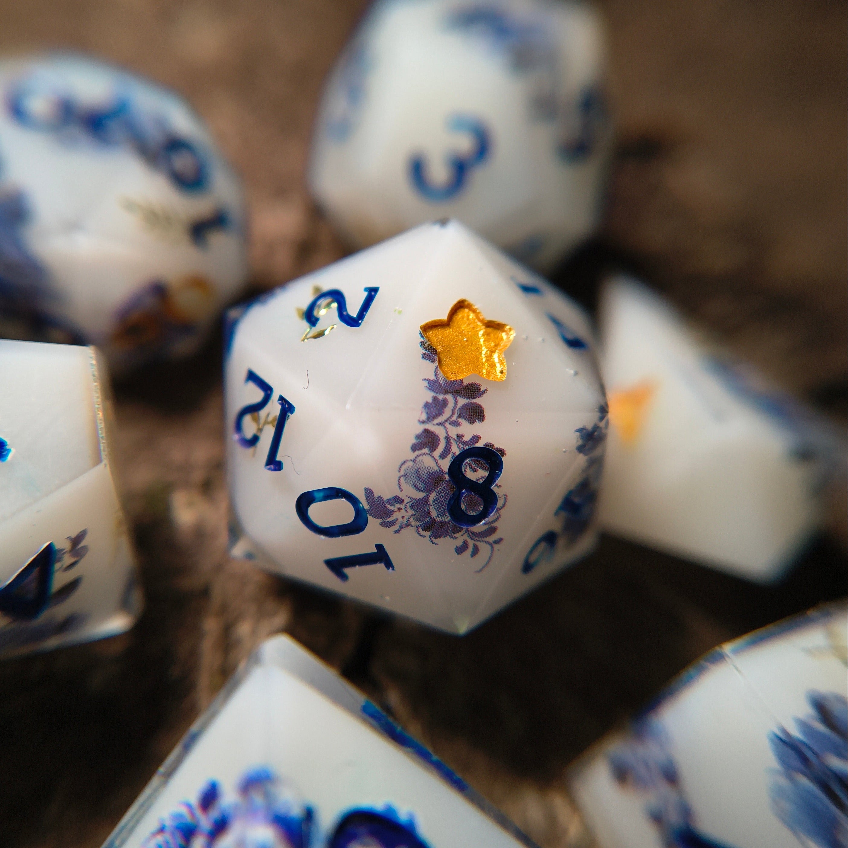 Close-up of white dice with porcelain patterning on a wood surface