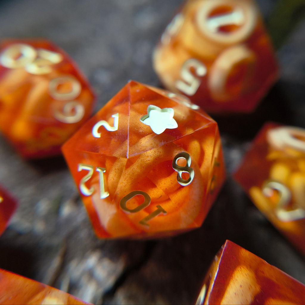 Close-up of red polyhedral dice with circular noodle colored inclusions on a wood surface
